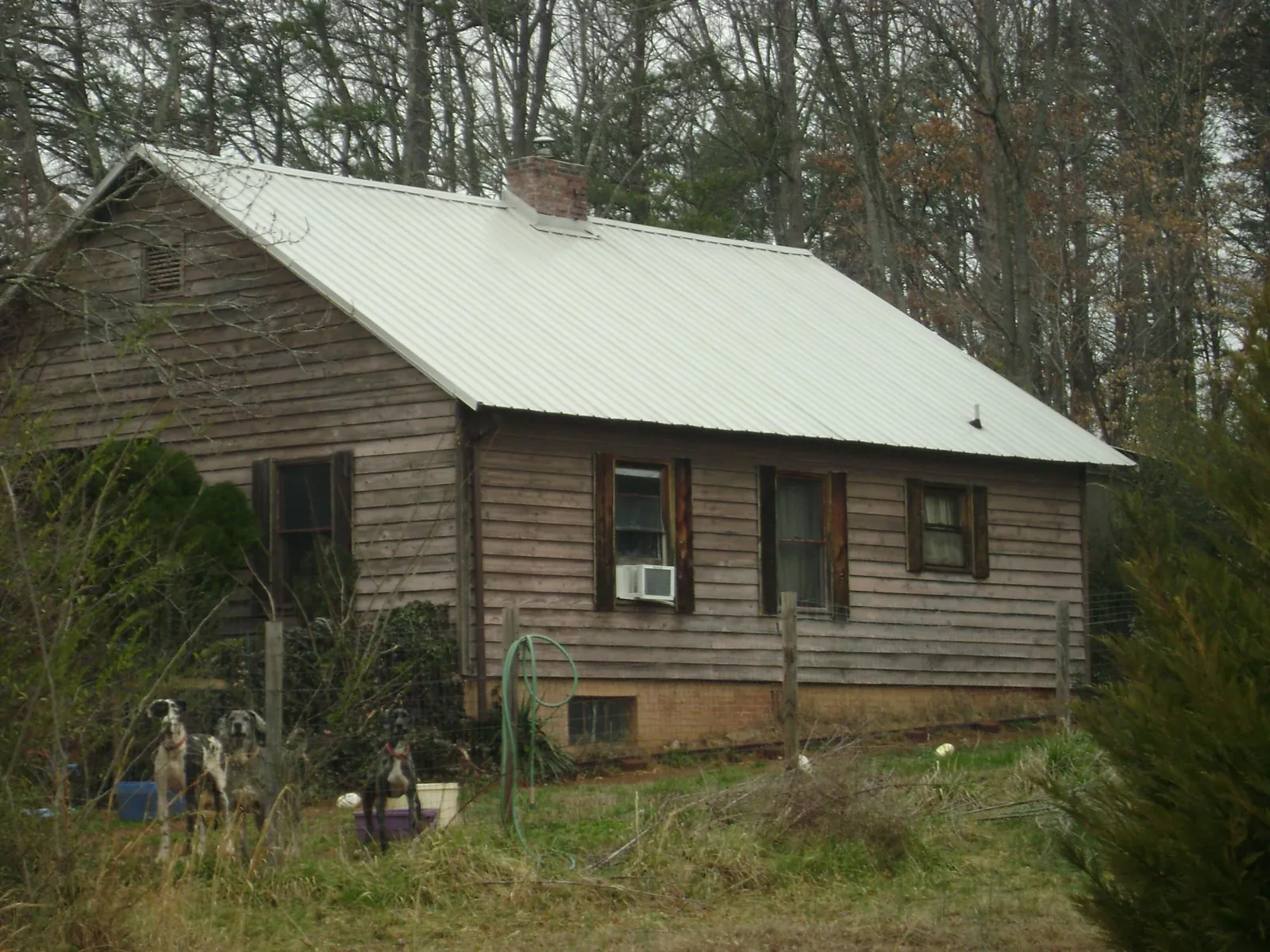 White metal roof on an old wood sided farmhouse, from a Metal Roof Installation job in Hartland
